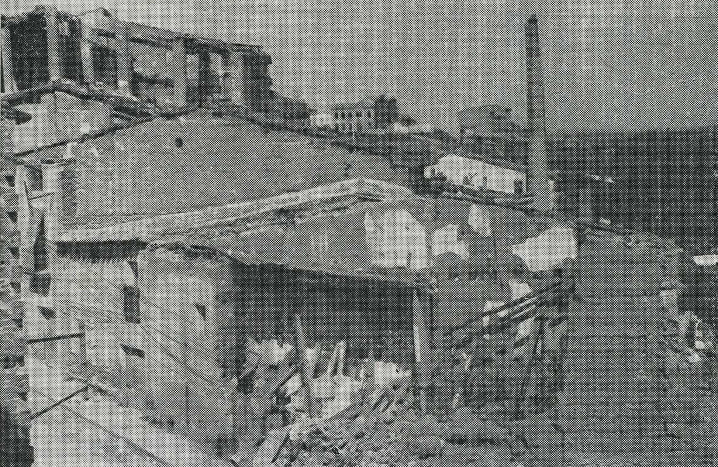 Detall d'una casa destruïda amb una xemeneia en peu al fons